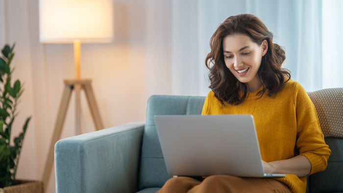 Client trader smiling while looking away from laptop